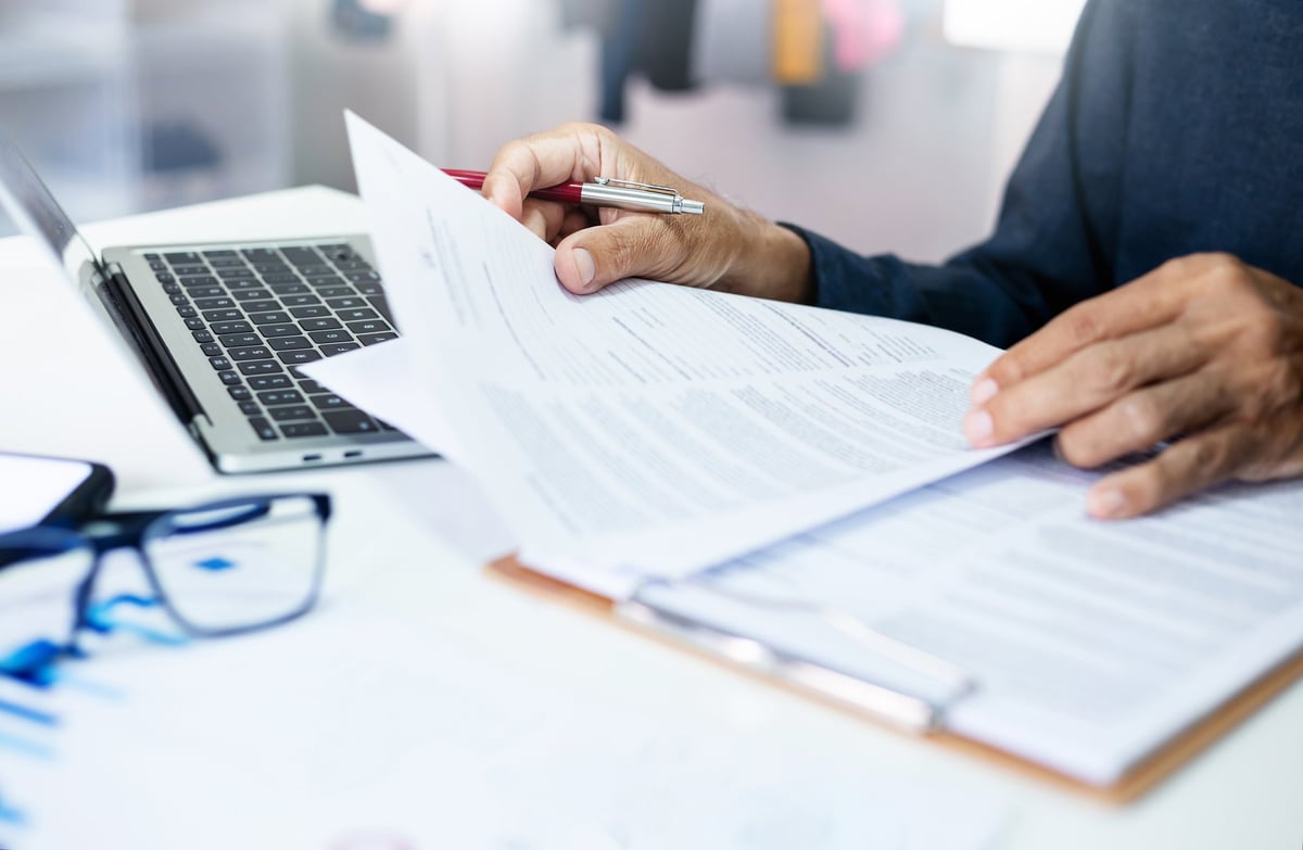 Senior advisor reviewing tax legal recovery documents and financial reports with business executive